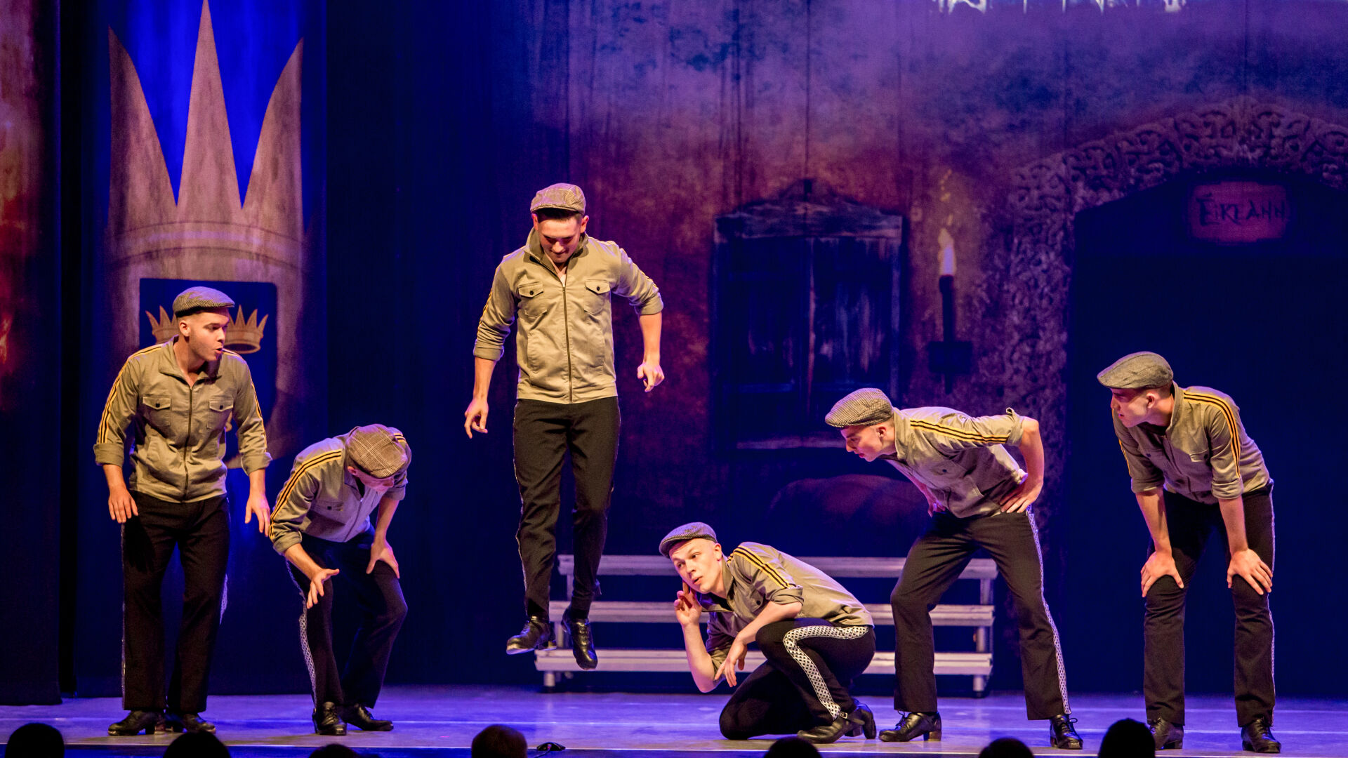 group of male dancers performing on stage for A Taste of Ireland. One of them is jumping technique.