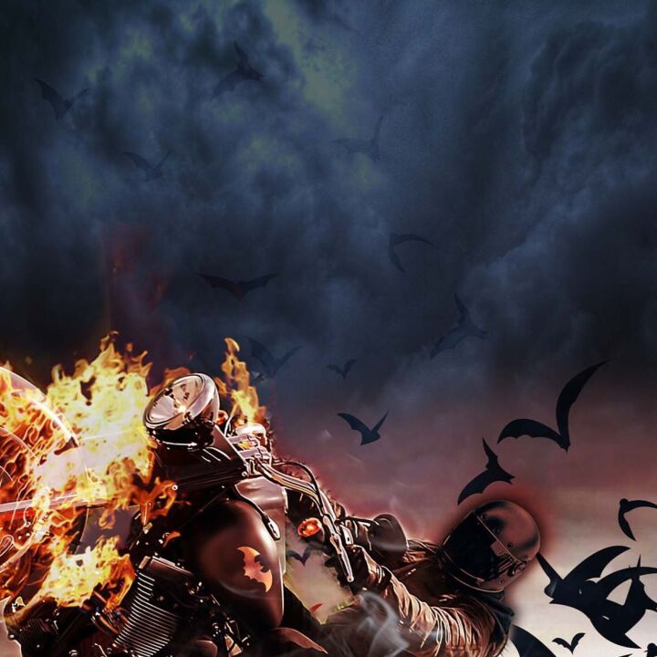A motorcycle rider is riding with a background that includes fire, bats, and a dark cloudy sky.