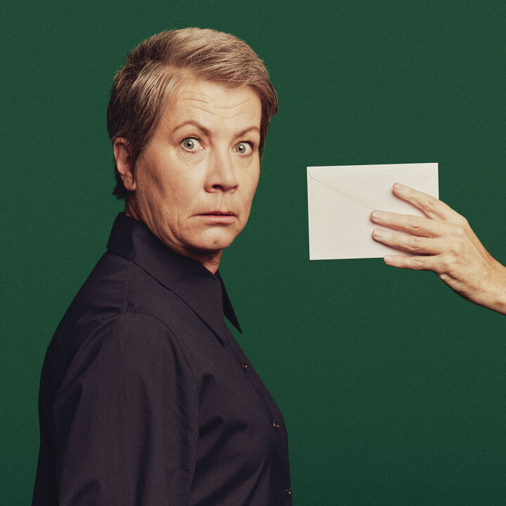 Confused woman being handed an envelope